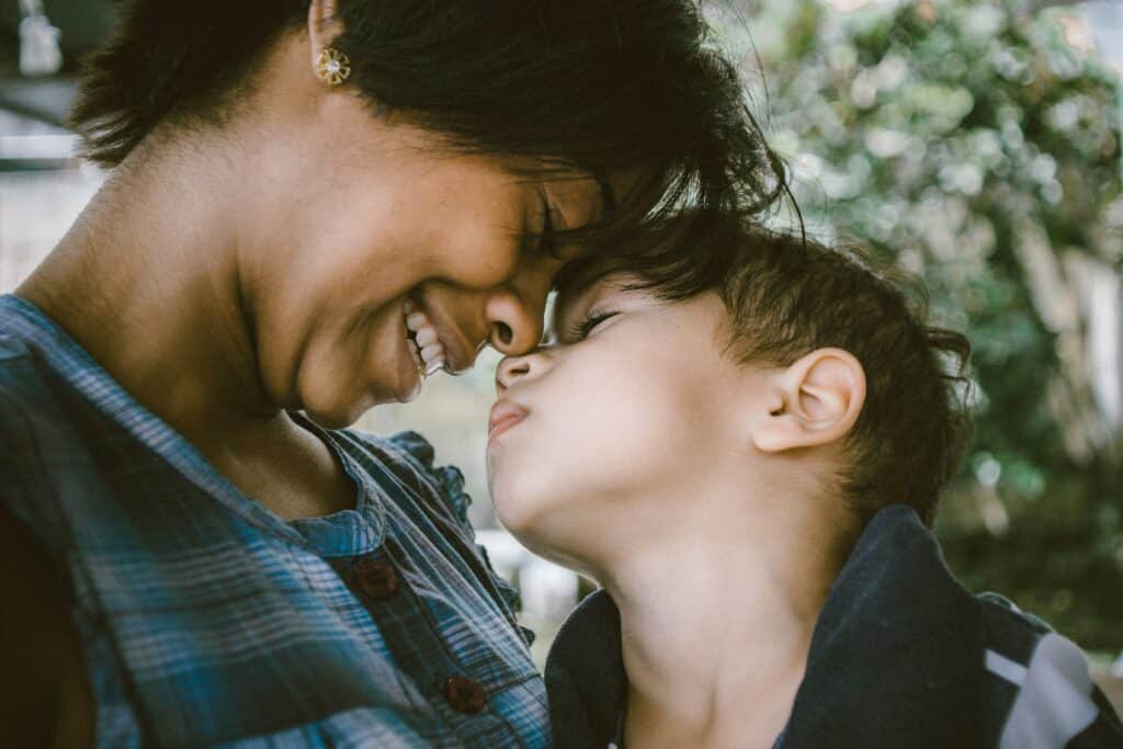 Woman smiling touching foreheads with a small child