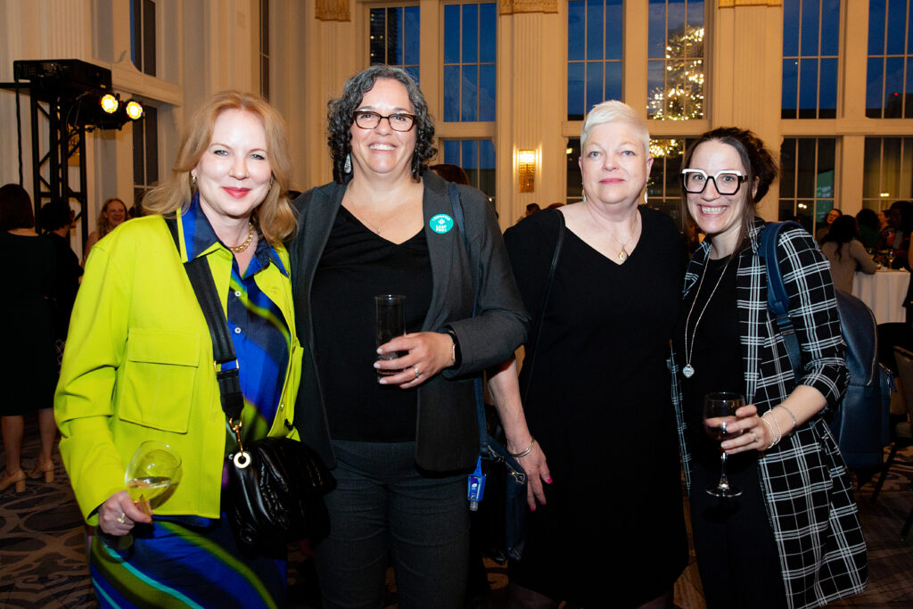 Photo of four attendees posing together from the 2025 Evening for Equality event.