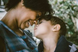 Woman smiling touching foreheads with a small child