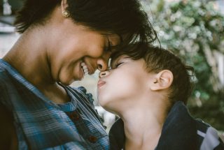 Woman smiling touching foreheads with a small child
