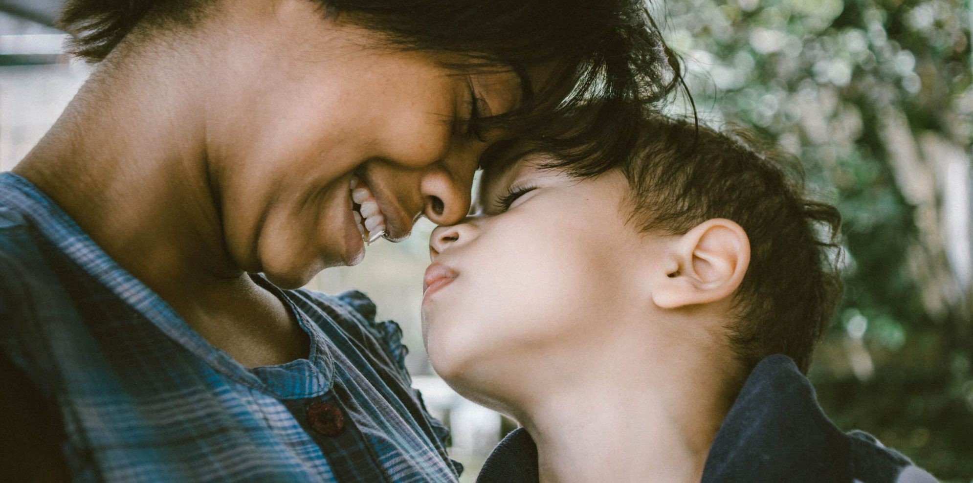 Woman smiling touching foreheads with a small child