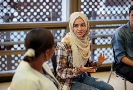 Muslim college students talking to a group in a counseling session - mental health concepts